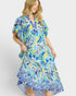 Woman wearing a colorful patterned dress on a white background