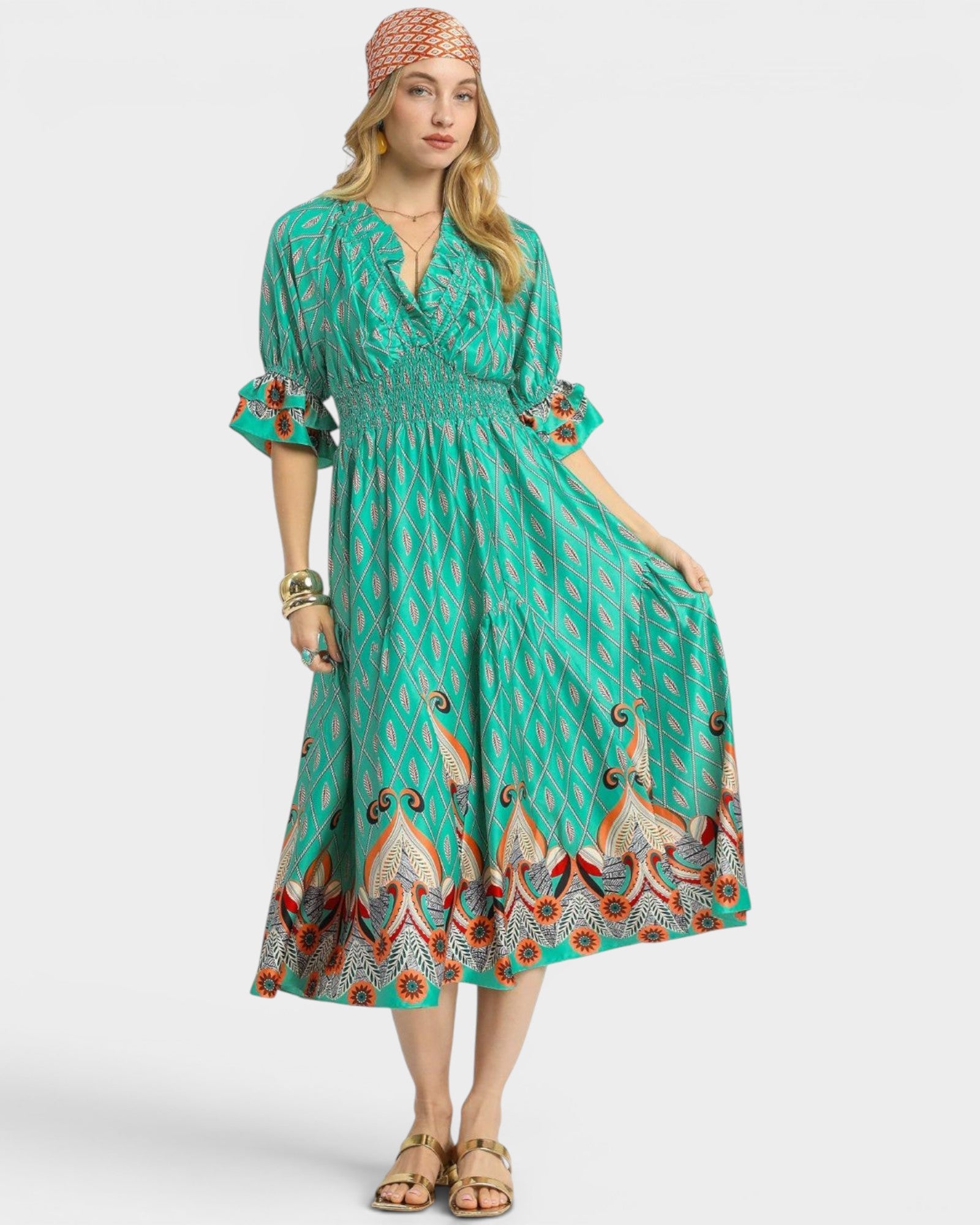Woman wearing a green patterned dress on a white background