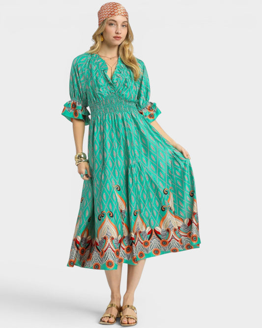 Woman wearing a green patterned dress on a white background