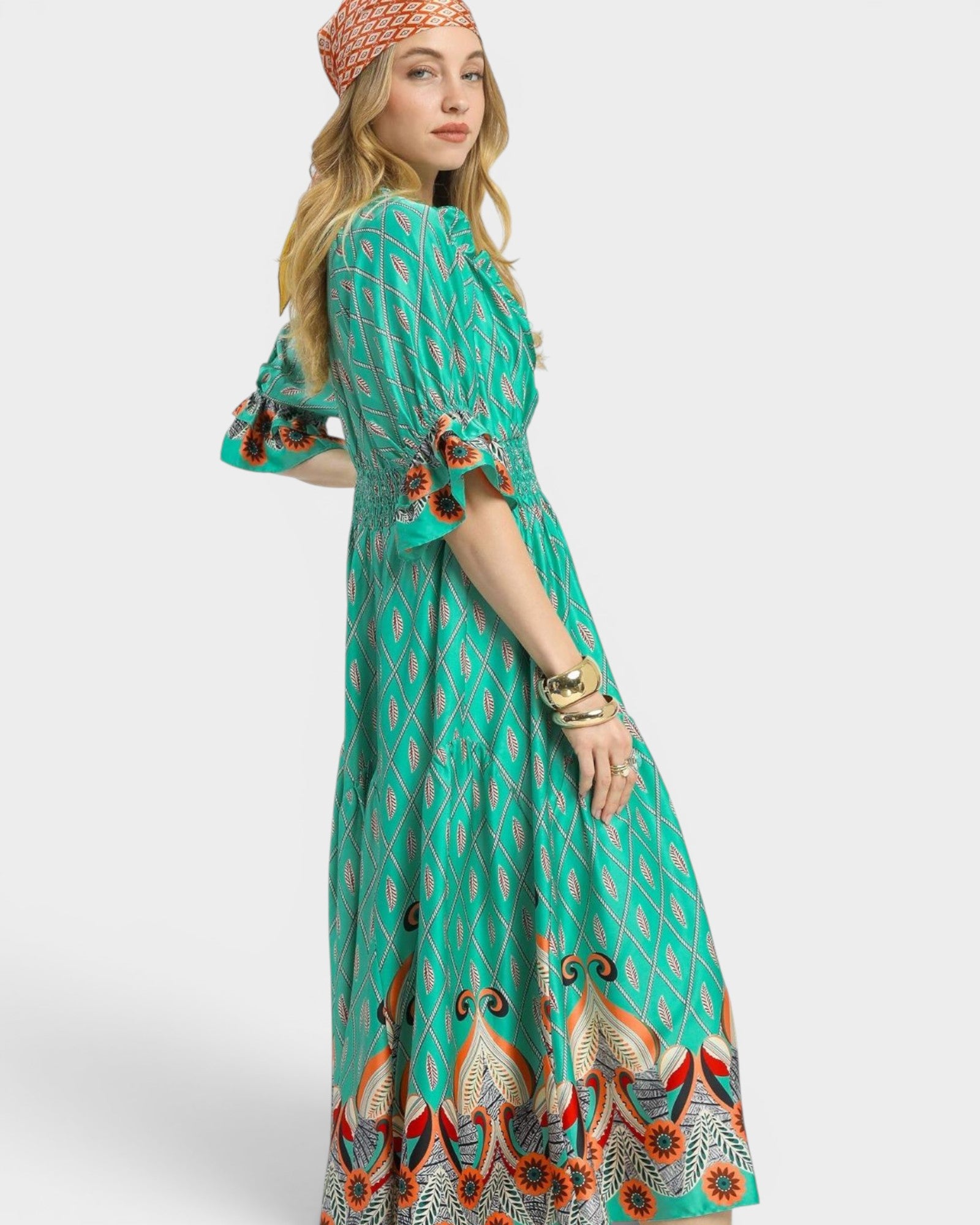 Woman wearing a green patterned dress on a white background