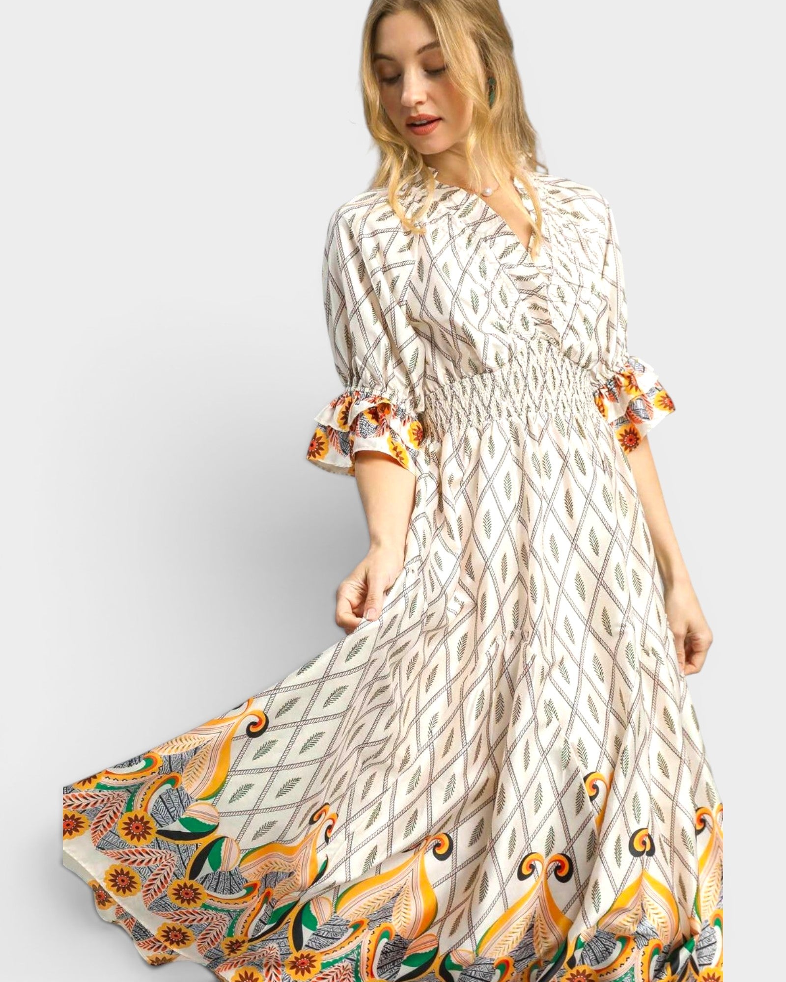 Woman wearing a long, patterned dress with a white background