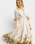 Woman wearing a long, patterned dress with a white background
