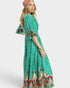 Woman wearing a green patterned dress on a white background