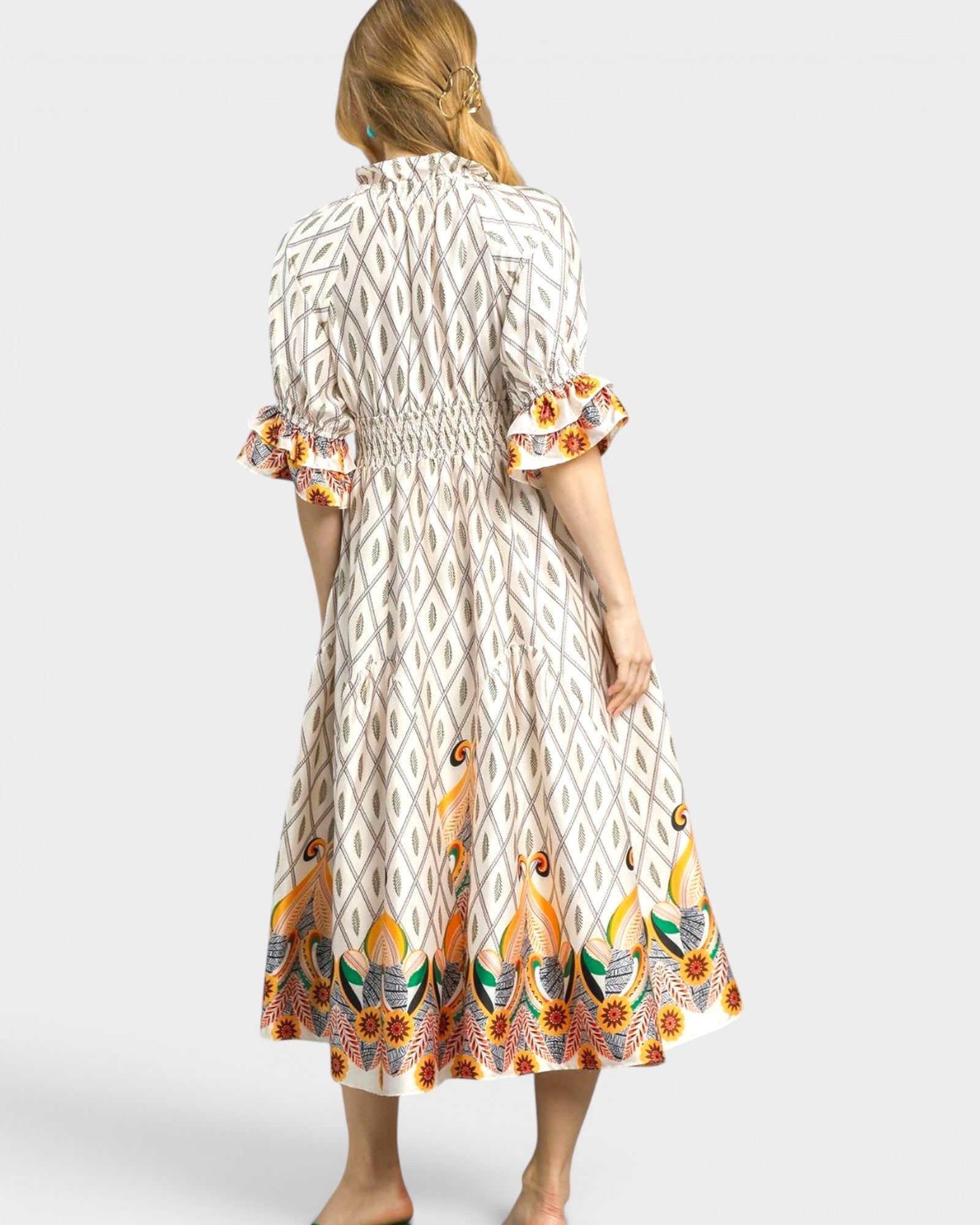 Woman wearing a patterned dress with a white background