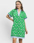 Woman wearing a green dress with white floral pattern on a plain background