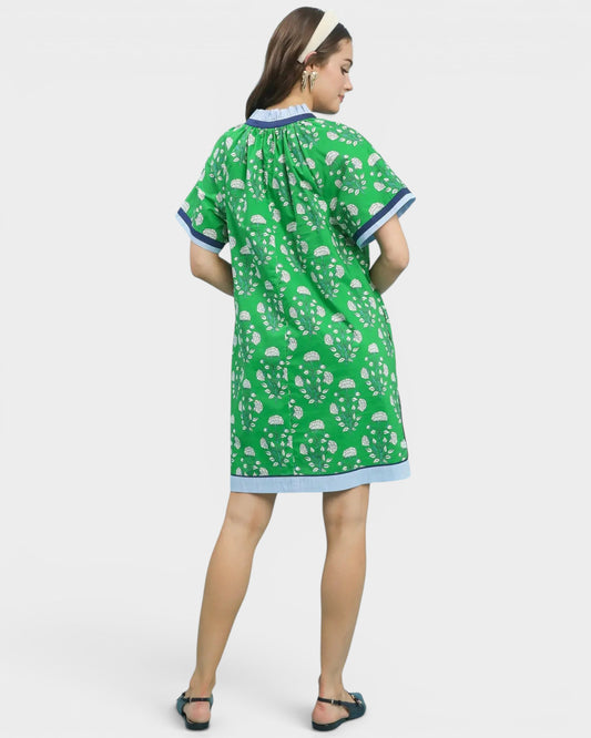 Woman wearing a green patterned dress on a white background