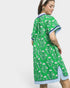 Woman wearing a green patterned dress with a white background
