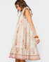 Woman wearing a white dress with orange floral pattern on a white background