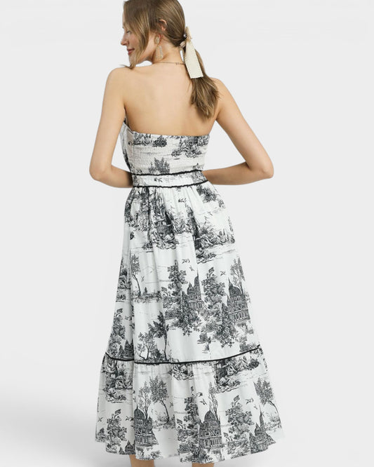Woman wearing a strapless dress with black and white floral pattern on a white background
