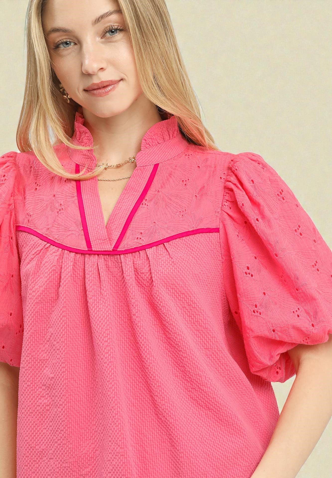 Woman wearing a pink blouse with a plain background