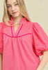 Woman wearing a pink blouse with a plain background
