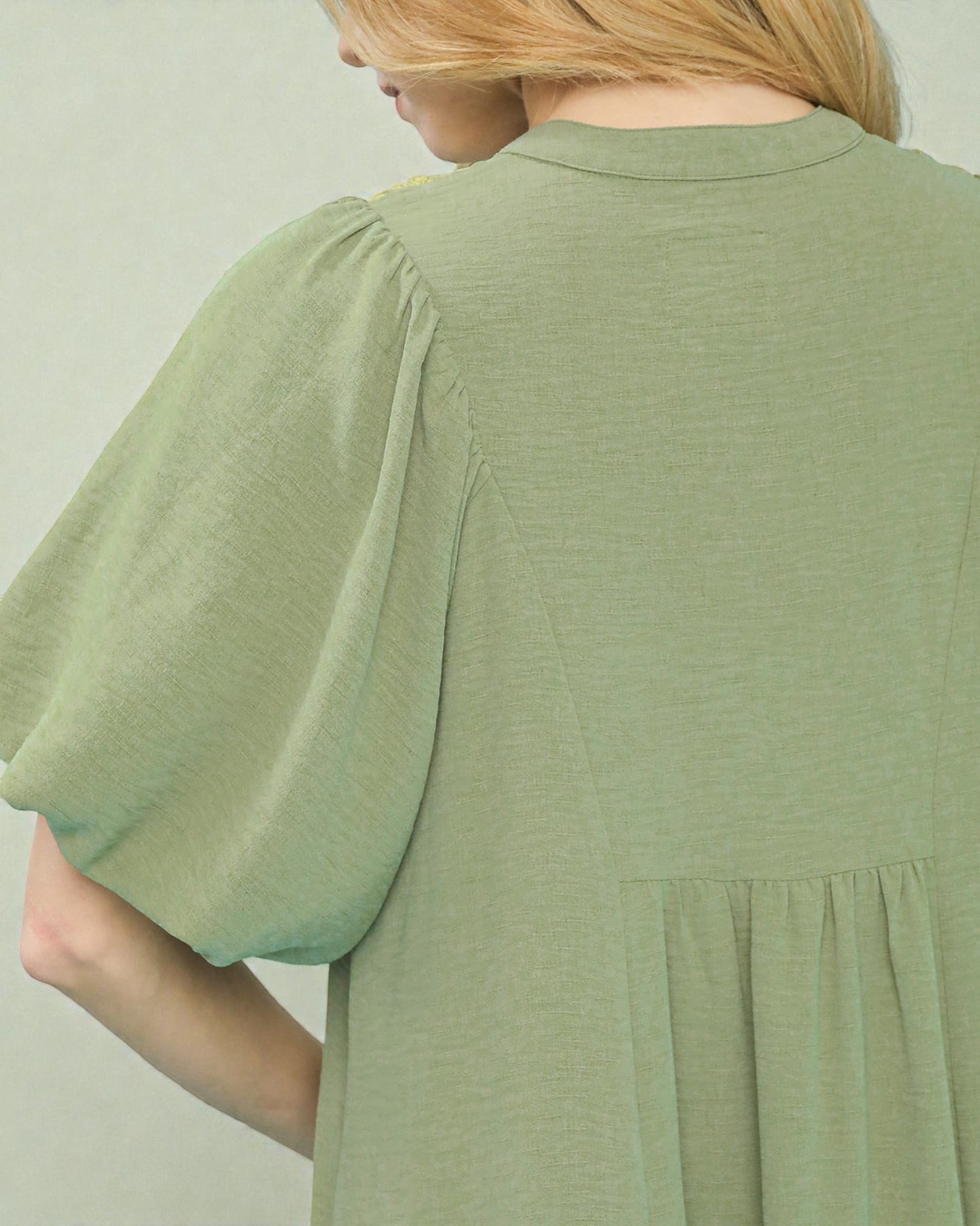 Green dress with short sleeves on a plain background