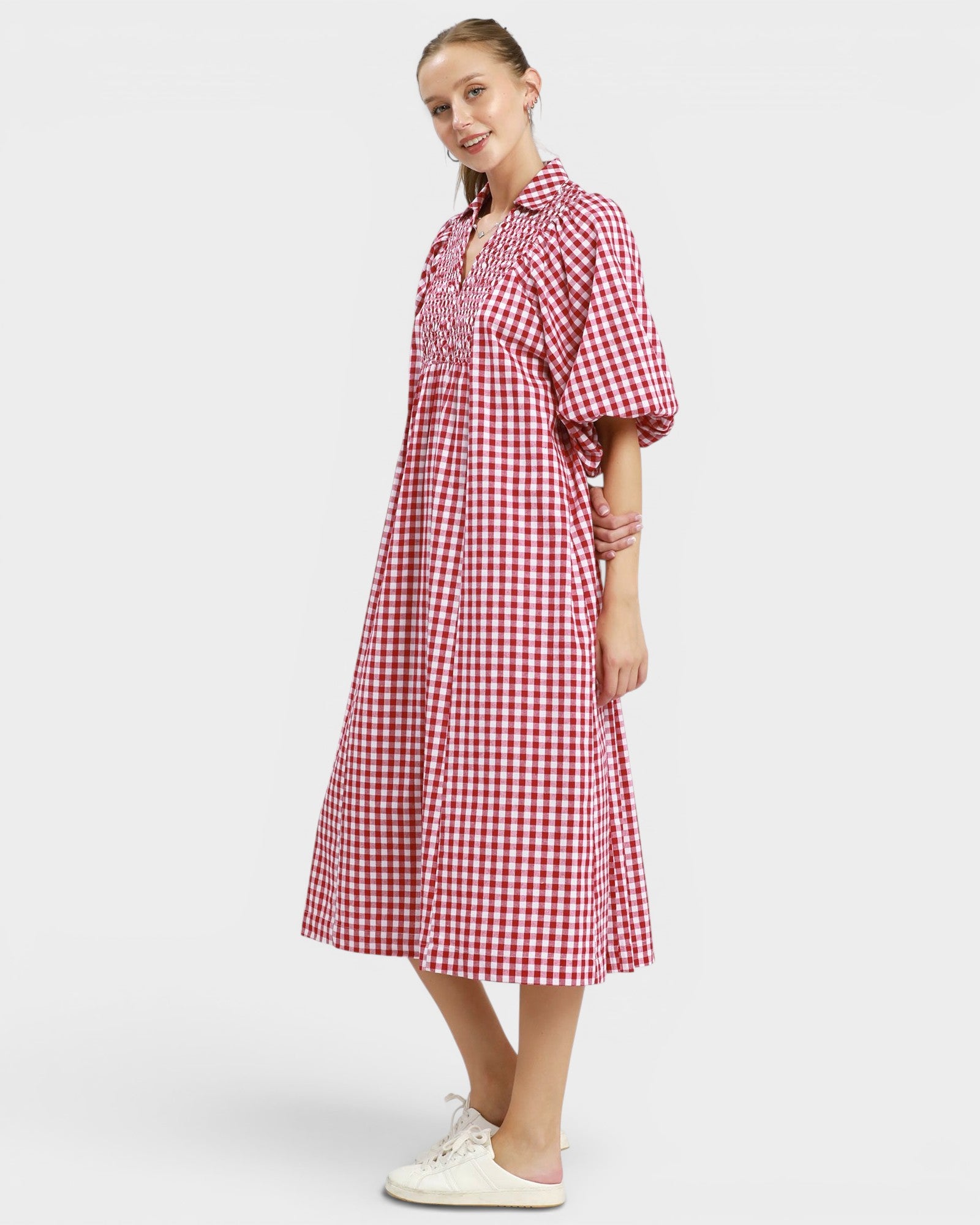 Woman wearing a red and white checkered dress on a plain background