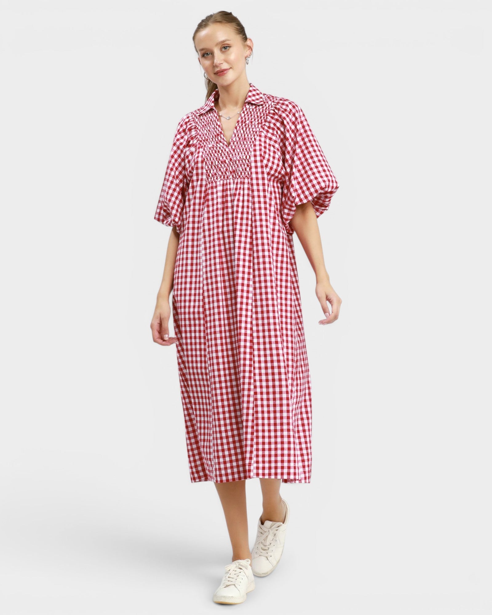 Woman wearing a red and white checkered dress on a white background