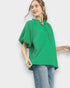 Woman wearing a green blouse and blue jeans on a white background