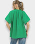 Person wearing a green blouse with short sleeves against a white background