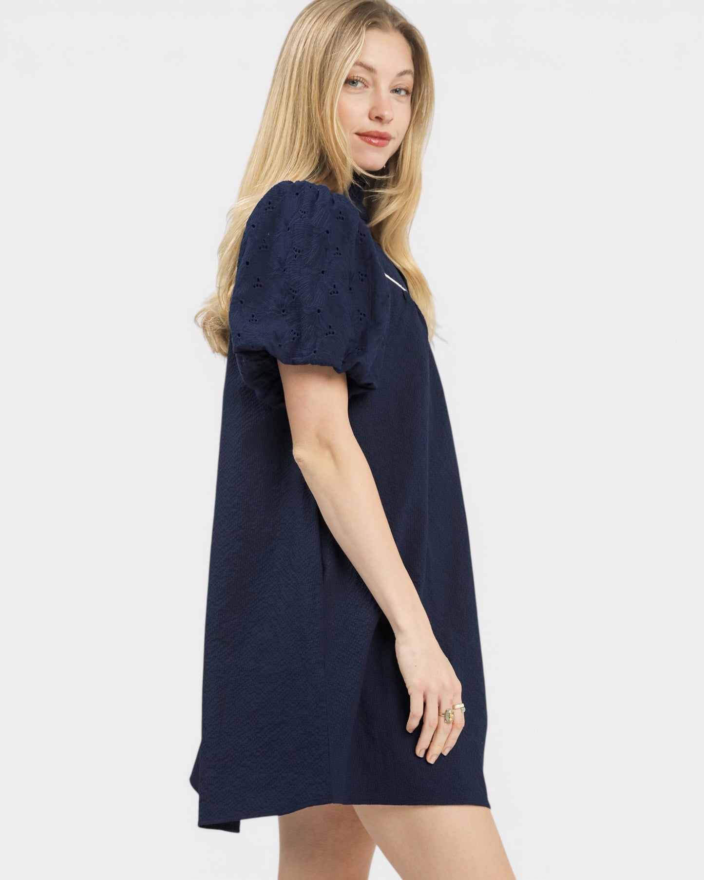 Woman wearing a navy blue dress on a white background