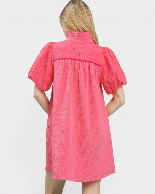 Pink dress with puff sleeves worn by a person on a white background