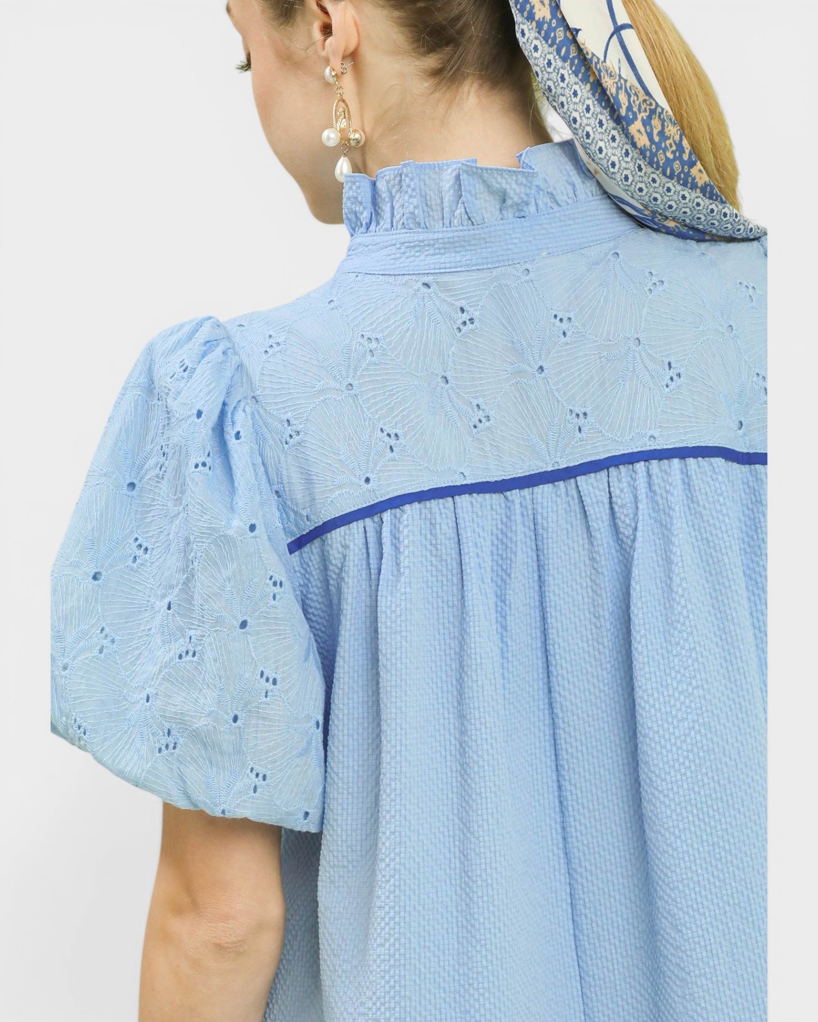 Woman wearing a light blue dress with a white background
