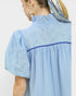 Woman wearing a light blue dress with a white background