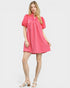 Woman wearing a pink dress with puff sleeves on a white background