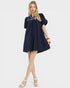 Woman wearing a navy dress with white trim on a white background