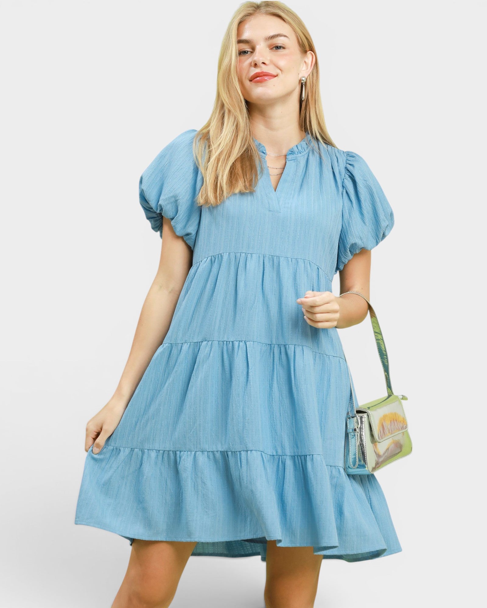 Woman wearing a blue dress with a plain background
