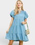 Woman wearing a blue dress with a plain background