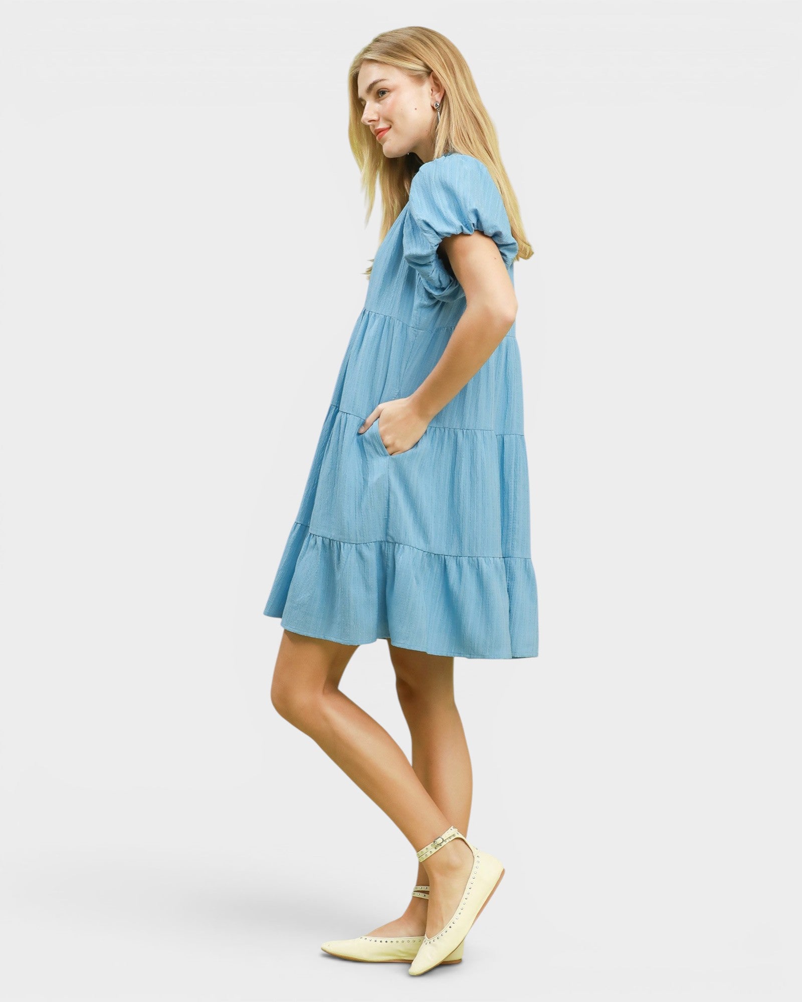 Woman wearing a light blue dress on a white background