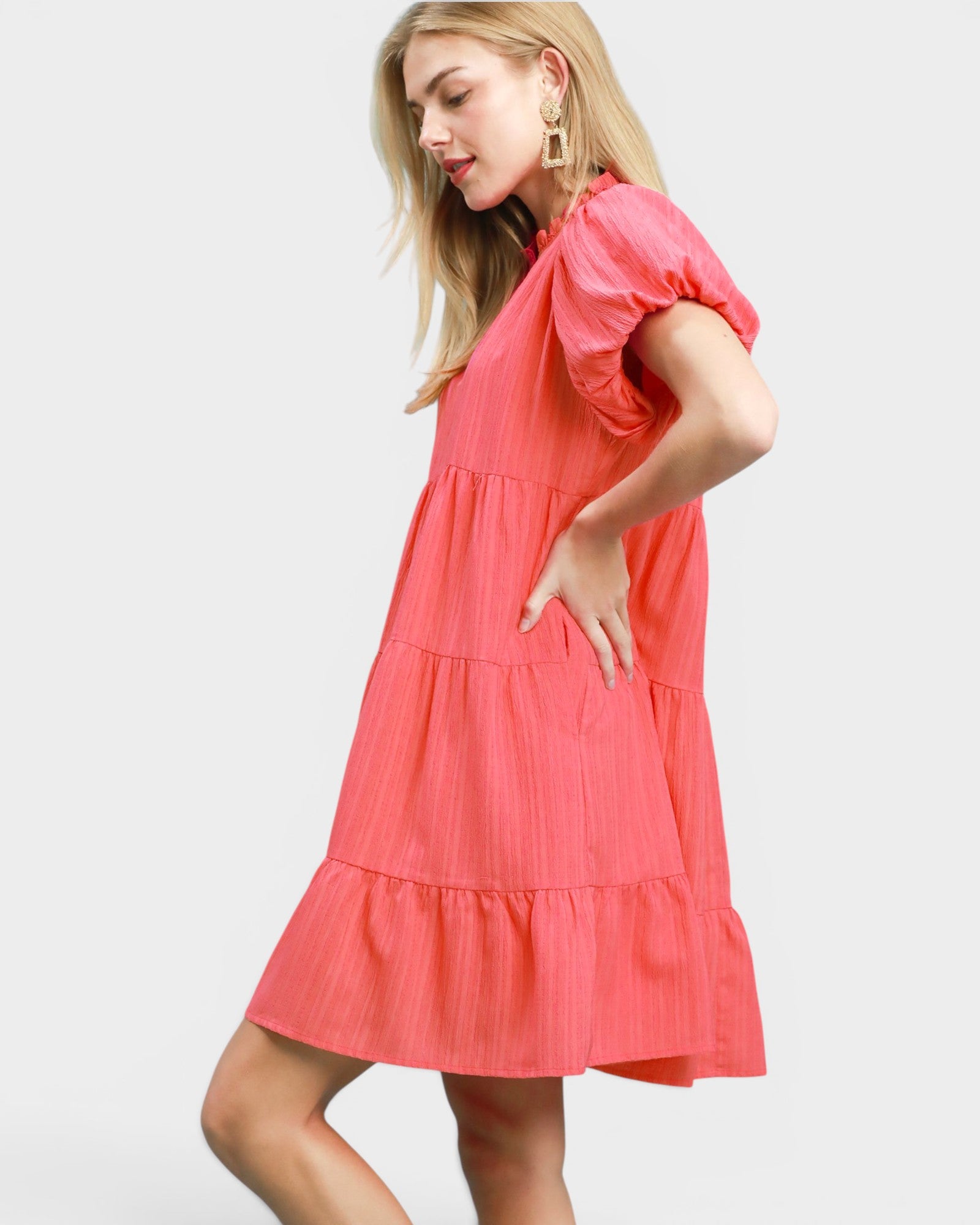 Woman wearing a coral dress on a white background