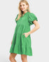 Woman wearing a green dress with puff sleeves on a white background