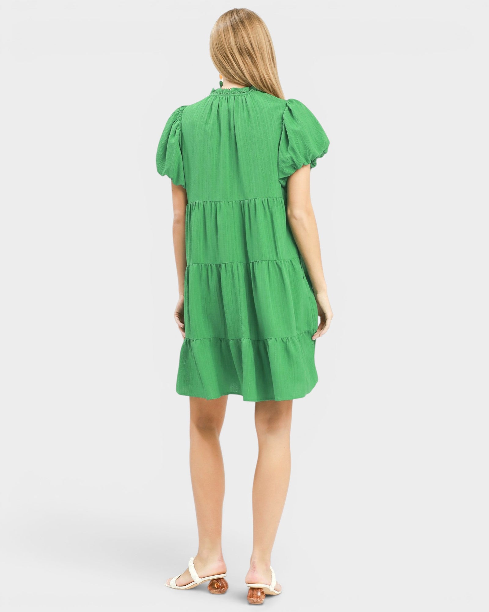 Green dress worn by a person on a white background
