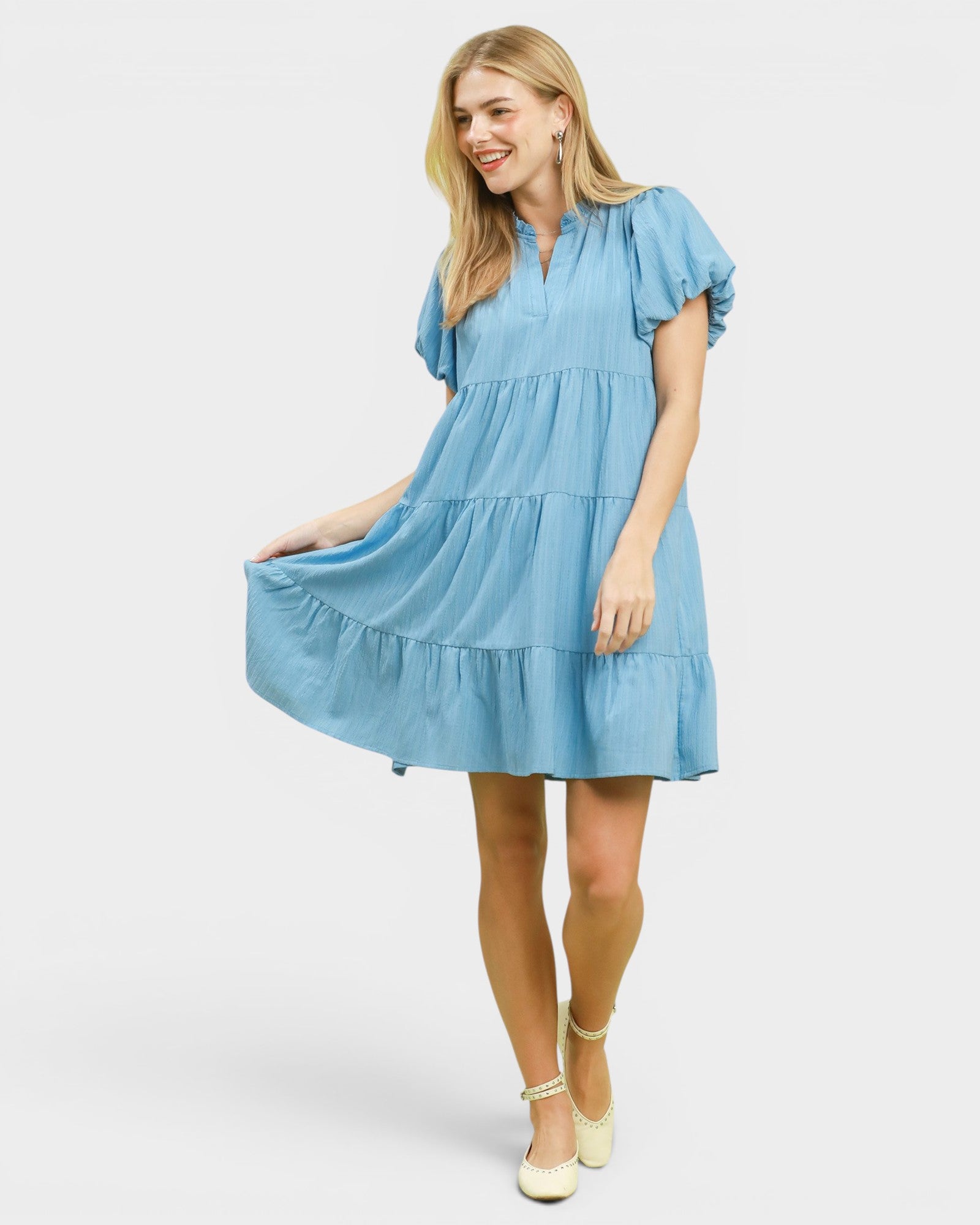 Woman wearing a light blue dress on a white background