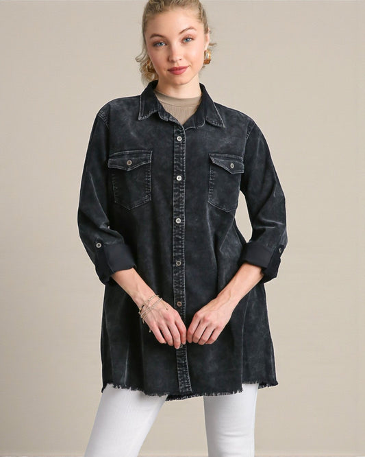 Woman wearing a black denim shirt over a beige top on a beige background