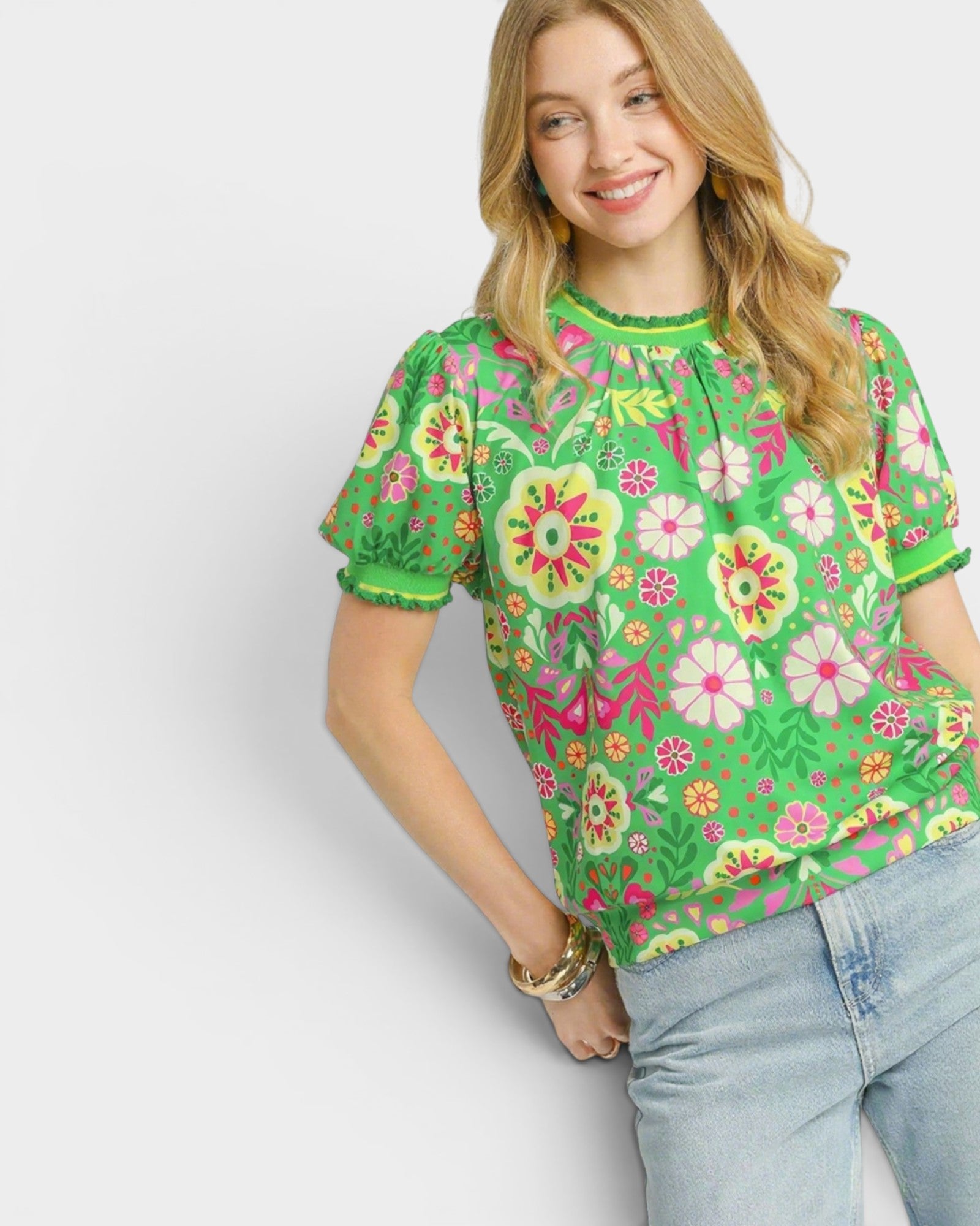 Woman wearing a green floral blouse against a white background