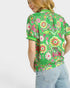 Woman wearing a green floral patterned shirt on a white background