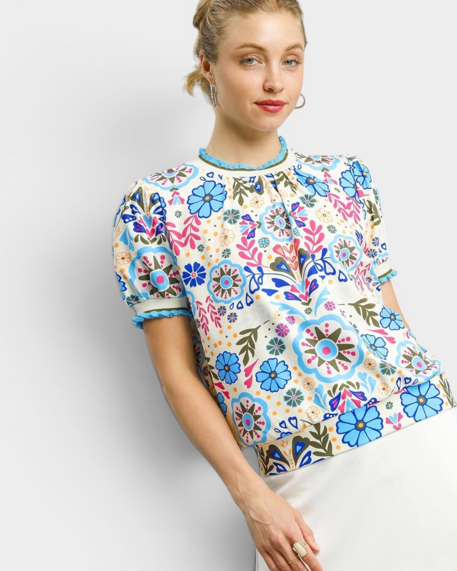 Woman wearing a colorful floral patterned blouse on a white background