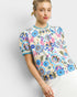 Woman wearing a colorful floral patterned blouse on a white background