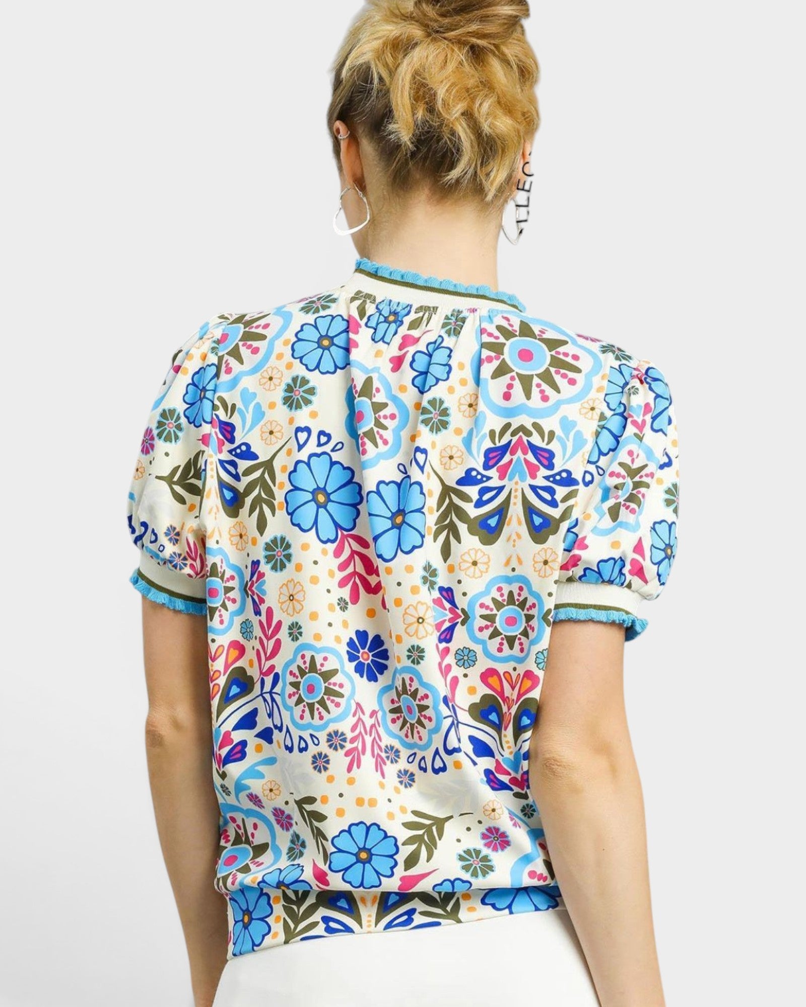 Person wearing a colorful floral patterned shirt on a white background