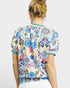 Person wearing a colorful floral patterned shirt on a white background