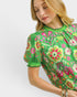 Woman wearing a green floral blouse with a white background