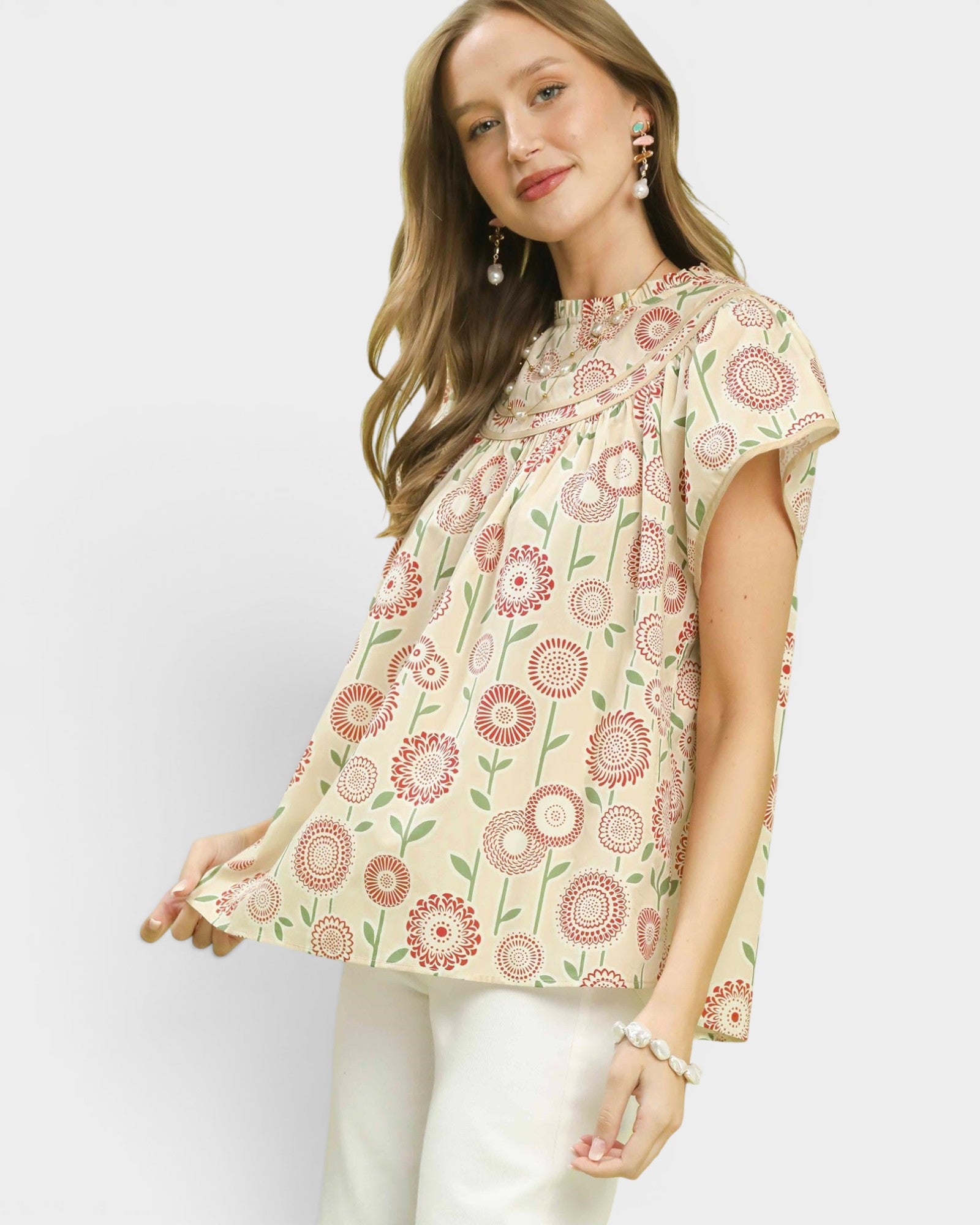 Woman wearing a floral patterned top against a white background