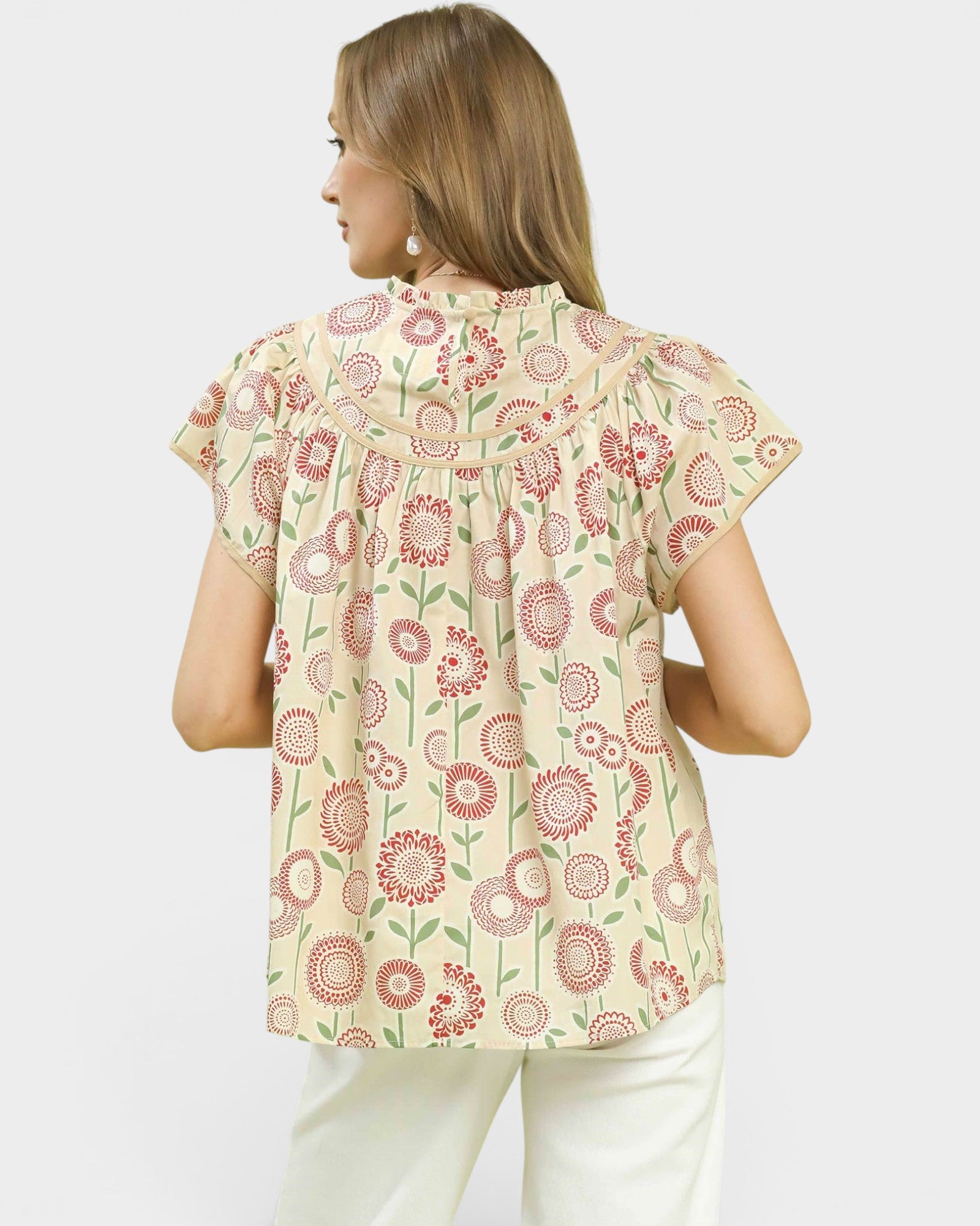 Woman wearing a floral patterned top on a white background