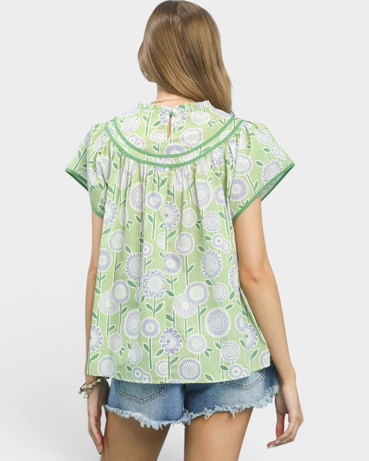 Woman wearing a green floral patterned shirt on a white background