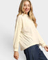 Woman wearing a beige sweater and blue jeans on a white background