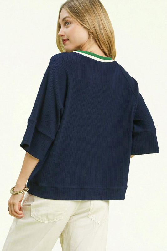 Woman wearing a navy blue sweater with a white background