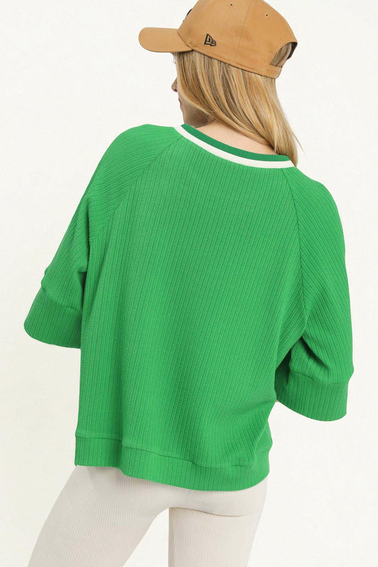 Person wearing a green sweater and beige cap on a white background