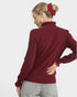 Woman wearing a burgundy sweater with a plain background