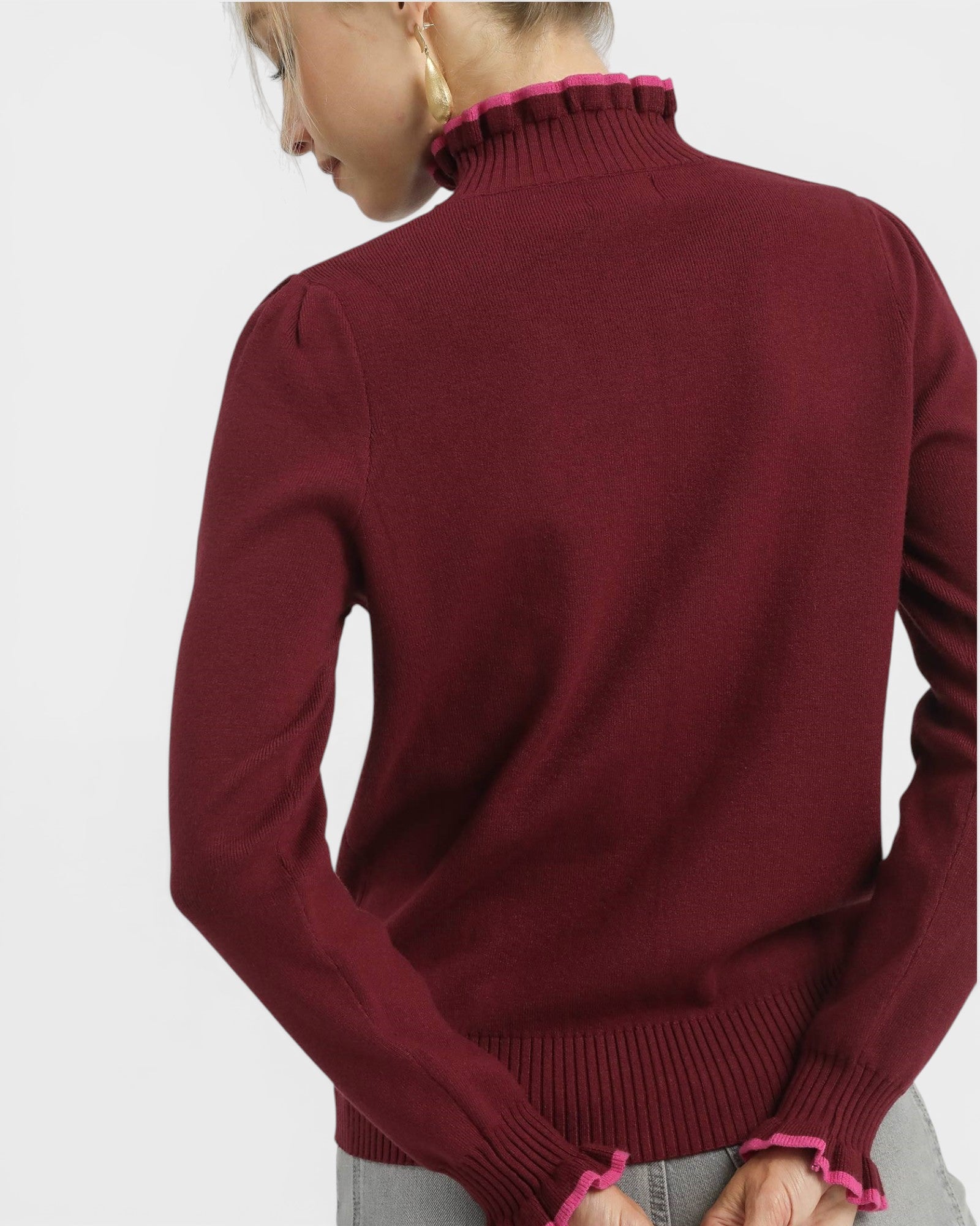 Maroon sweater with pink trim on a plain background
