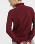Maroon sweater with pink trim on a plain background